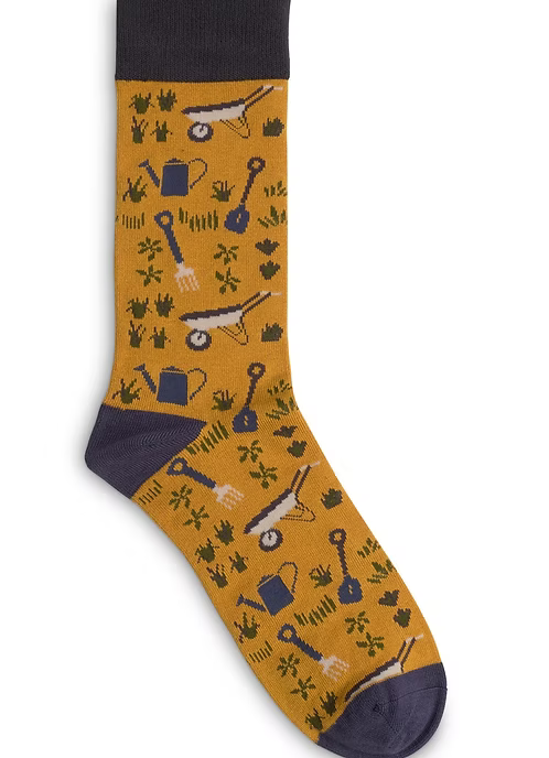 Gardening-themed sock with tools and plants on a mustard background