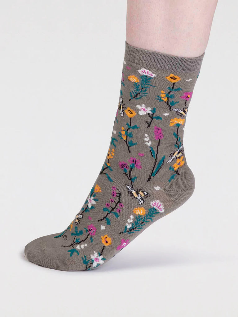 Pear green organic cotton sock with pink, yellow and white flowers with green leaves and bumble bees