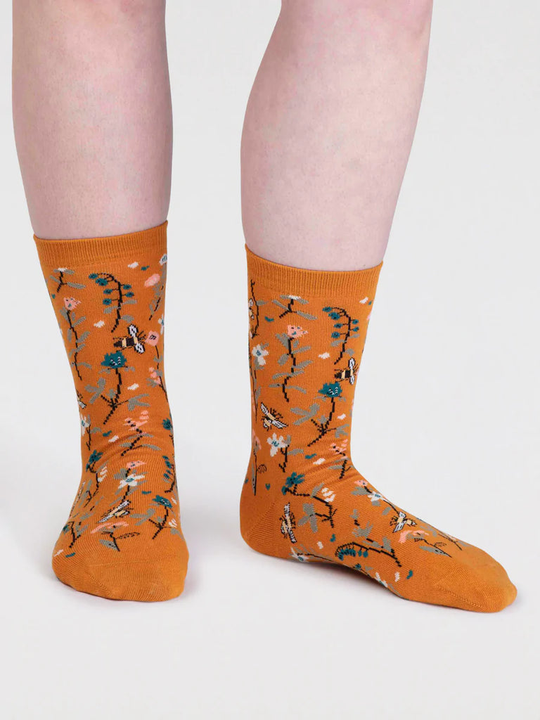 Turmeric Yellow organic cotton sock with pink, green and white flowers with brown leaves and bumble bees