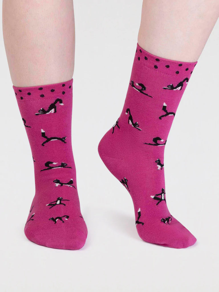 Raspberry Pink bamboo and cotton socks with a black cat in yoga positions print and black spots around the cuff