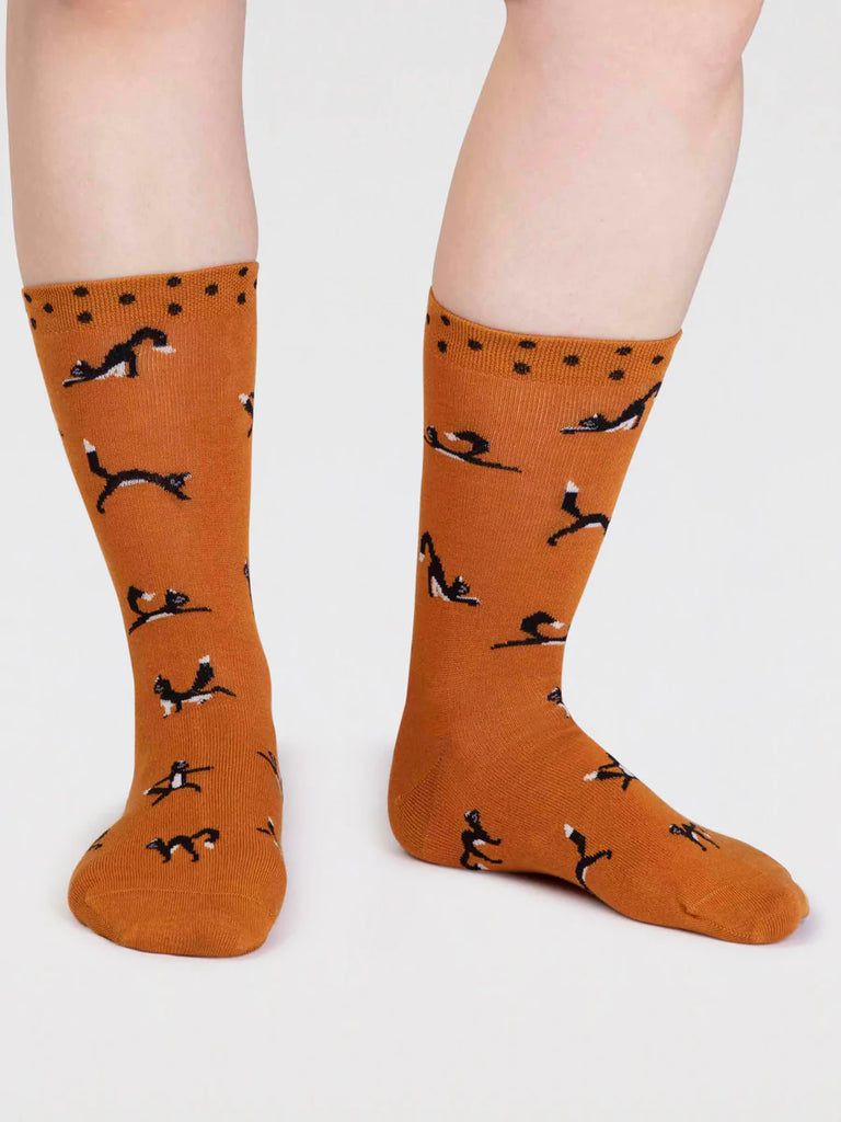Turmeric yellow bamboo and cotton socks with a black cat in yoga positions print and black spots around the cuff