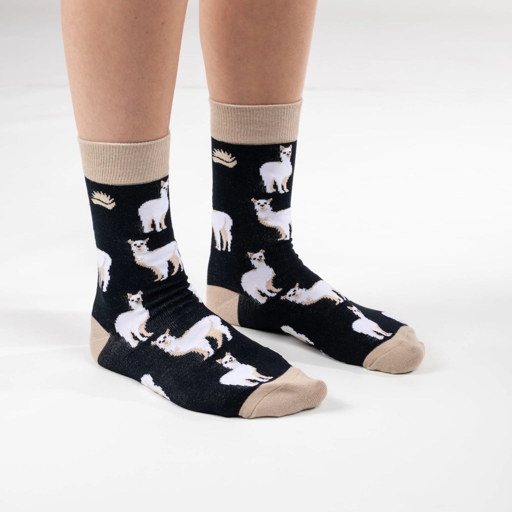 Front on view of model in super soft premium quality bamboo socks with a beige and white Alpaca print on a black background