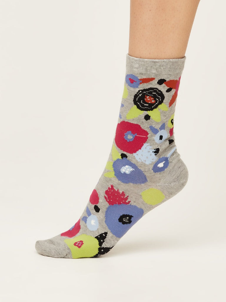 Side view of abstract floral super soft premium quality organic socks in grey marle with green black blue and red flower design.